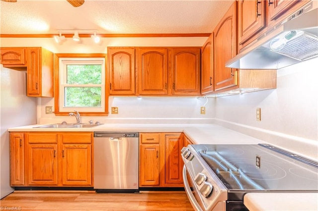 163 Ruth Ct, Winston-Salem, NC 27127 - kitchen with appliances with stainless steel finishes, under cabinet range hood, a sink, light countertops, and brown cabinetry