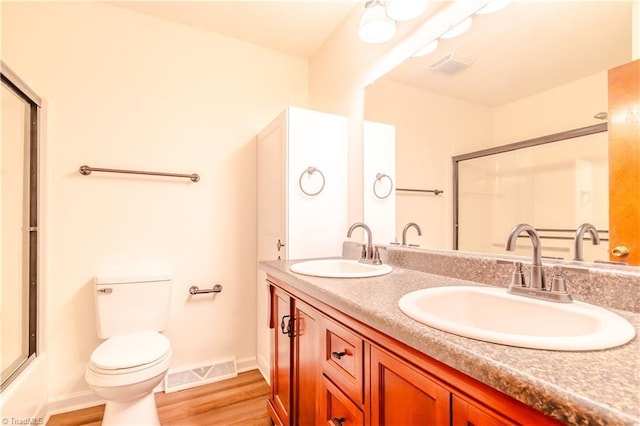 163 Ruth Ct, Winston-Salem, NC 27127 - bathroom with an enclosed shower, wood finished floors, toilet, double vanity, and baseboards