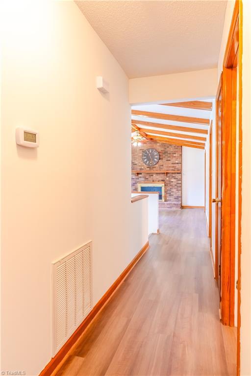 163 Ruth Ct, Winston-Salem, NC 27127 - corridor featuring wood finished floors, beamed ceiling, and baseboards