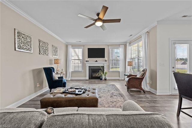 living room with ceiling fan, hardwood / wood-style flooring, ornamental molding, and a wealth of natural light