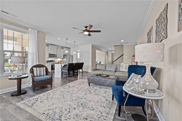 living room with ceiling fan, hardwood / wood-style flooring, and crown molding