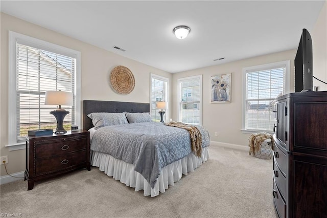 bedroom featuring multiple windows and light colored carpet