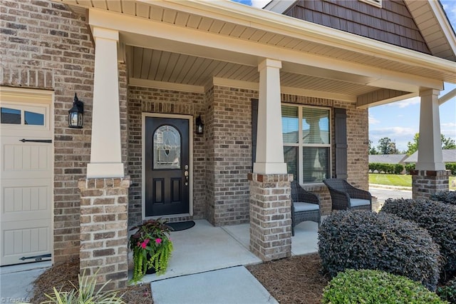 entrance to property with a garage and covered porch