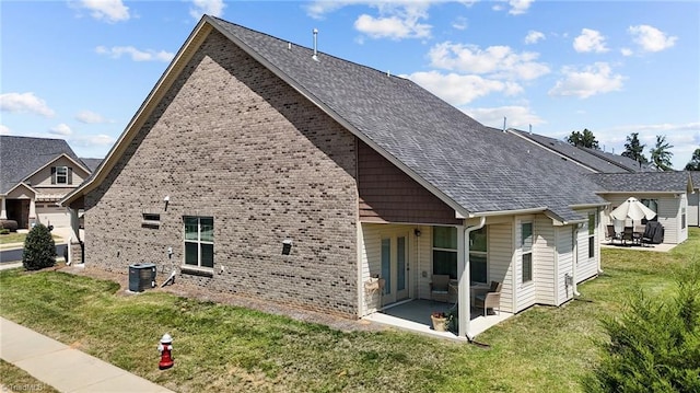 back of house with central AC, a patio area, and a yard