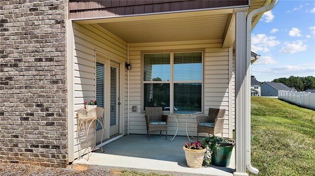 property entrance with a patio and a lawn