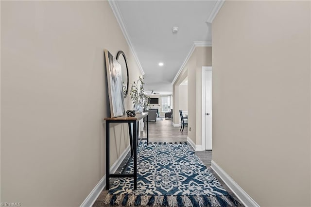 corridor with wood-type flooring and crown molding