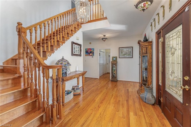 foyer entrance with a notable chandelier and light hardwood / wood-style flooring