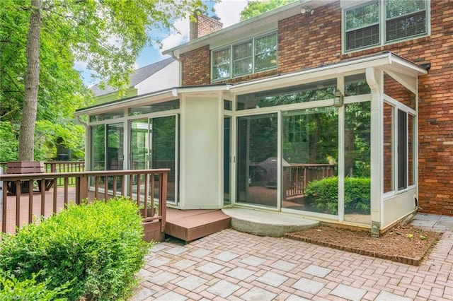 1315 Waybridge Ln, Winston-Salem, NC 27103 - rear view of property featuring a sunroom, a chimney, brick siding, and a wooden deck