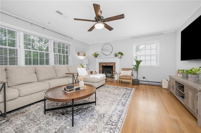 1315 Waybridge Ln, Winston-Salem, NC 27103 - living room with a ceiling fan, light wood-style floors, a baseboard heating unit, and a fireplace with raised hearth