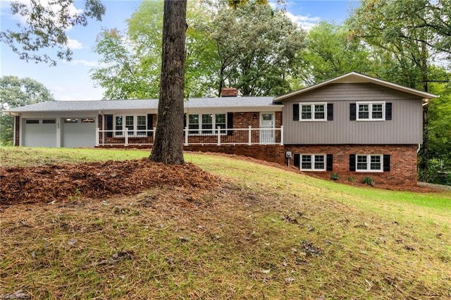 rear view of property with a garage and a lawn