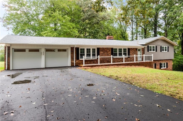 view of front of home featuring a front lawn, a porch, and a garage