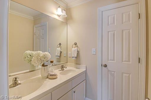 bathroom with vanity and ornamental molding