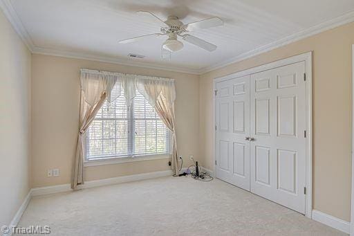 bedroom featuring ornamental molding, carpet, ceiling fan, and a closet