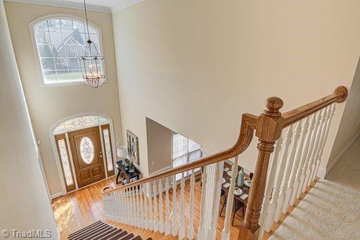 entrance foyer with a high ceiling, a notable chandelier, and hardwood / wood-style floors