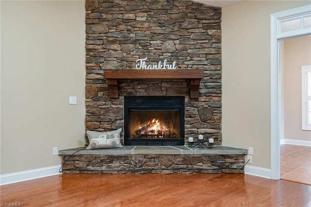 room details with hardwood / wood-style floors and a stone fireplace