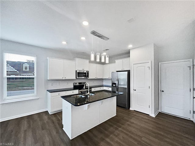 5810 Crestlawn Ct, Pfafftown, NC 27040 - kitchen with appliances with stainless steel finishes, dark countertops, dark wood-style flooring, white cabinets, and a center island with sink