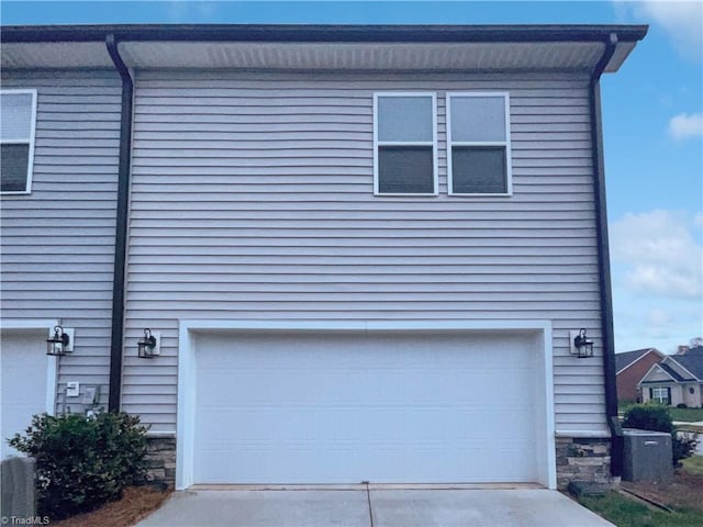 5810 Crestlawn Ct, Pfafftown, NC 27040 - view of side of property featuring driveway, an attached garage, and stone siding