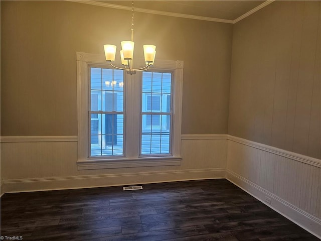 unfurnished dining area featuring dark wood-style flooring, wainscoting, a chandelier, visible vents, and ornamental molding