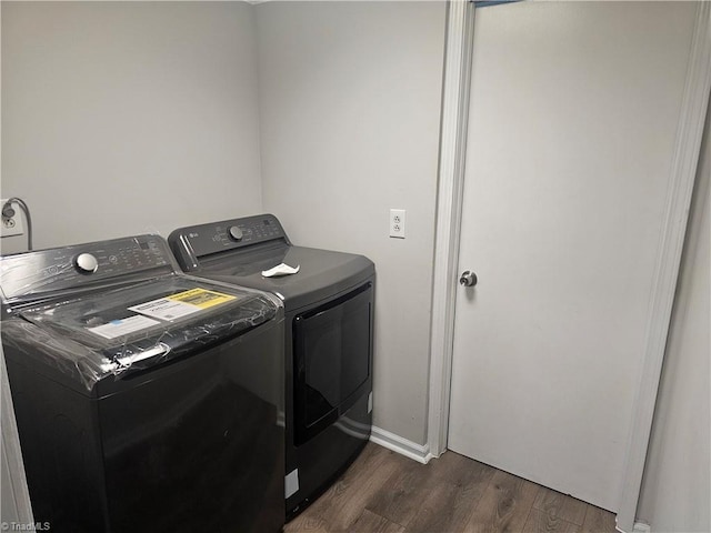 laundry area featuring dark wood-type flooring, laundry area, baseboards, and washer and dryer