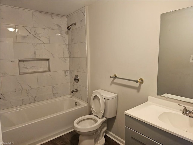bathroom with wood finished floors, baseboards, vanity, toilet, and bathing tub / shower combination