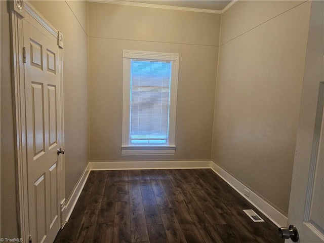 spare room featuring ornamental molding and dark wood-type flooring