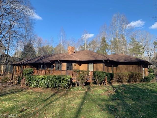 view of side of property with a chimney and a yard