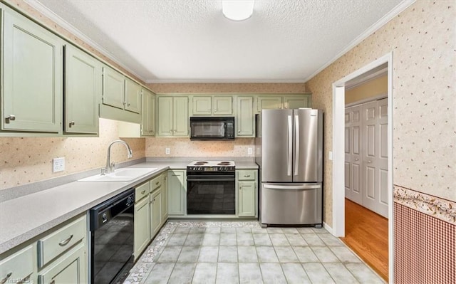 kitchen featuring sink, green cabinetry, crown molding, and black appliances