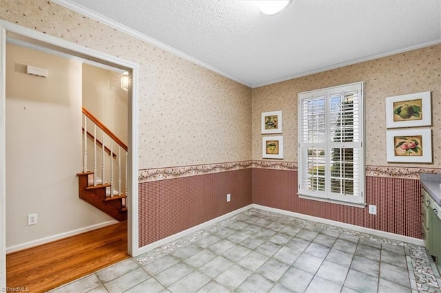 spare room with crown molding and a textured ceiling