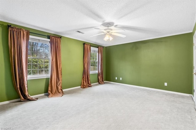 unfurnished room featuring carpet, ceiling fan, ornamental molding, and a textured ceiling