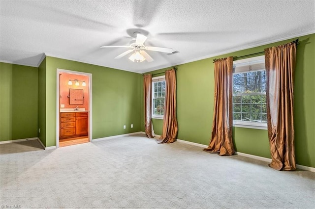 unfurnished bedroom featuring a textured ceiling, ensuite bathroom, ceiling fan, and light colored carpet