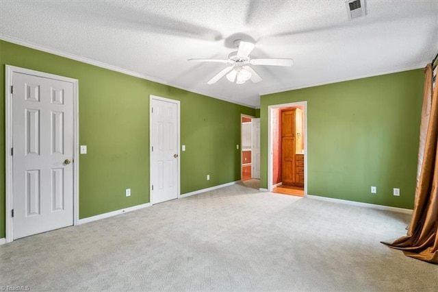 unfurnished bedroom featuring a textured ceiling, ceiling fan, ensuite bathroom, and light carpet