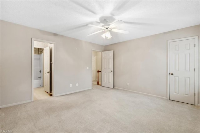 unfurnished bedroom featuring light carpet, ensuite bath, and ceiling fan