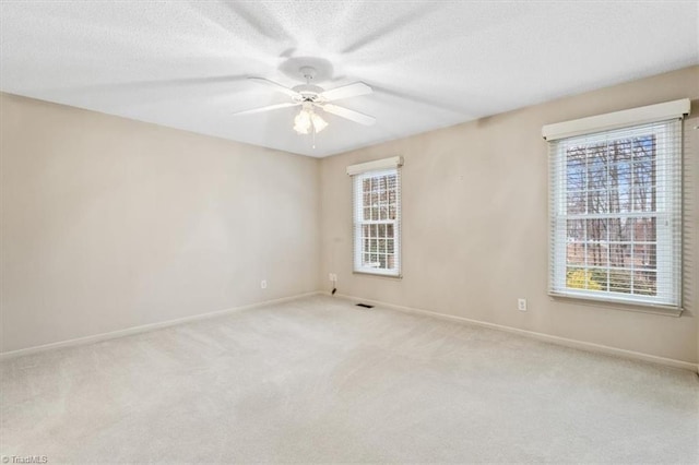 spare room featuring ceiling fan and light colored carpet