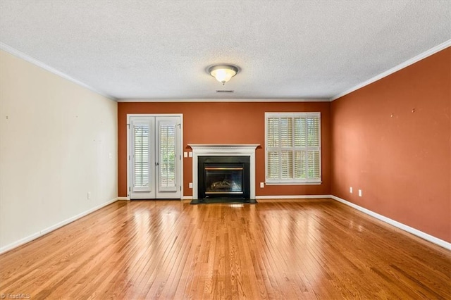 unfurnished living room featuring plenty of natural light, light hardwood / wood-style floors, and ornamental molding