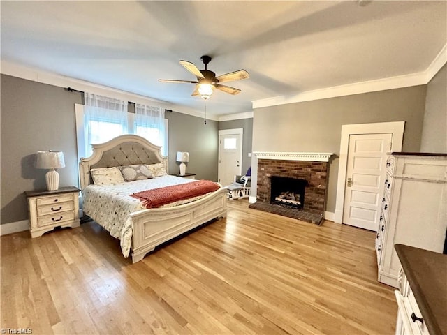 327 S Carolina Ave, Boonville, NC 27011 - bedroom with crown molding, light wood-type flooring, baseboards, a brick fireplace, and ceiling fan