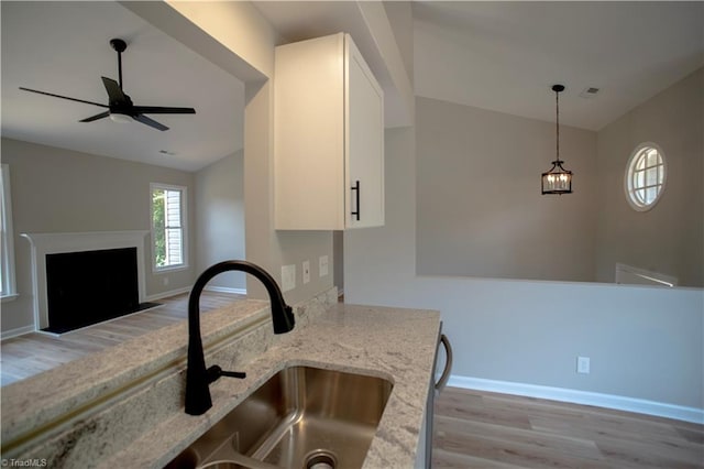 9048 Jefferson Woods Dr, King, NC 27045 - kitchen with light wood-style flooring, vaulted ceiling, white cabinetry, light stone counters, and open floor plan