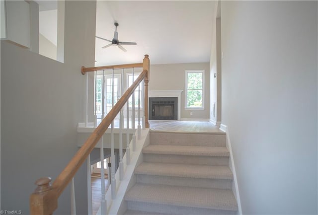 9048 Jefferson Woods Dr, King, NC 27045 - stairway with ceiling fan, a glass covered fireplace, and high vaulted ceiling