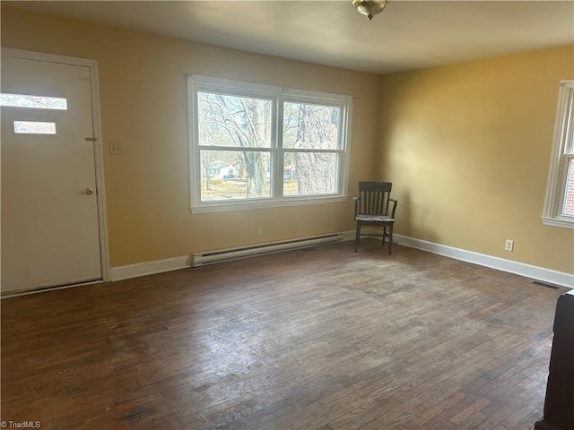 foyer entrance with visible vents, baseboards, baseboard heating, and wood finished floors