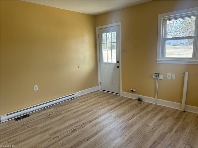 doorway featuring light wood-type flooring, a baseboard radiator, and baseboards