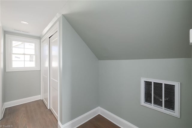 bonus room with wood-type flooring and vaulted ceiling