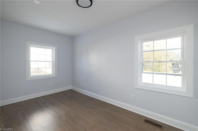 empty room with dark hardwood / wood-style flooring