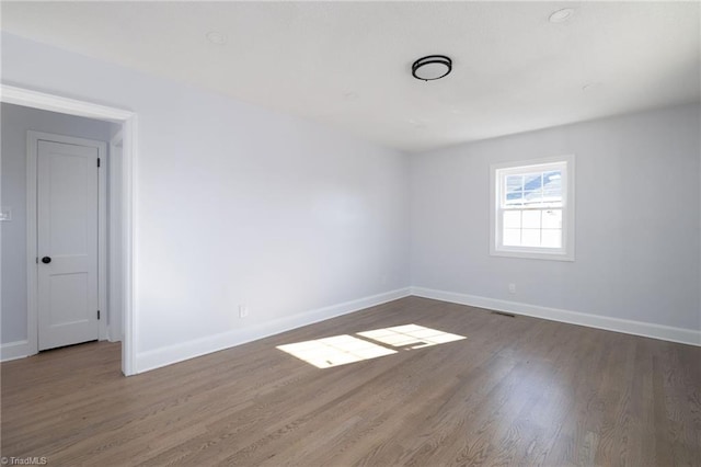 unfurnished room with dark hardwood / wood-style flooring