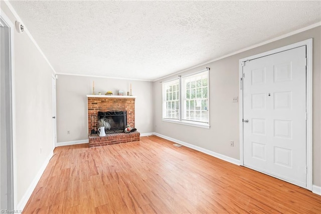 1765 K Fork Rd, Madison, NC 27025 - unfurnished living room featuring light wood finished floors, a textured ceiling, crown molding, a brick fireplace, and baseboards