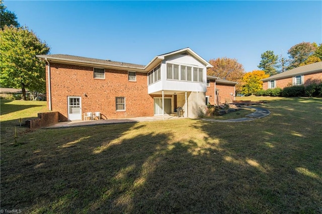 rear view of house with a patio area, a sunroom, and a lawn