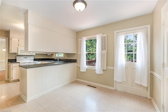 1601 Heraldry Ln, Greensboro, NC 27455 - kitchen with white appliances, dark countertops, a peninsula, and light flooring