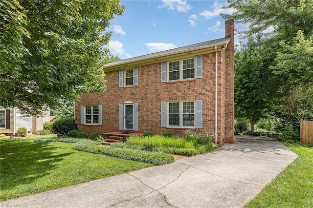 1601 Heraldry Ln, Greensboro, NC 27455 - colonial house with a chimney, driveway, a front yard, and brick siding