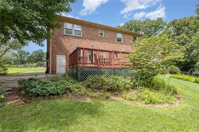1601 Heraldry Ln, Greensboro, NC 27455 - rear view of house featuring a wooden deck, a yard, brick siding, and concrete driveway