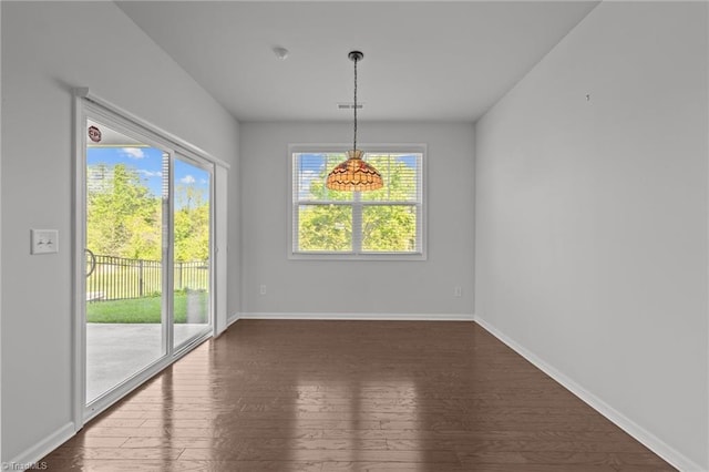 unfurnished dining area with baseboards, visible vents, and dark wood-style floors