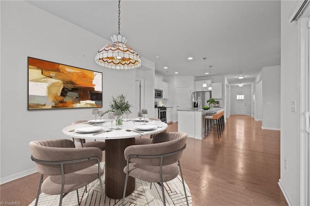 dining room with recessed lighting, light wood finished floors, and baseboards