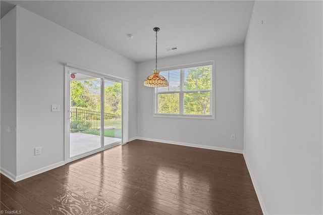 unfurnished dining area with dark wood finished floors, baseboards, and visible vents